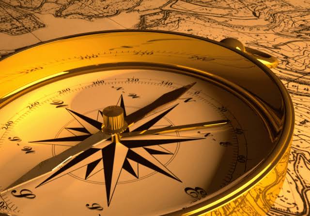 Golden compass on an antique map